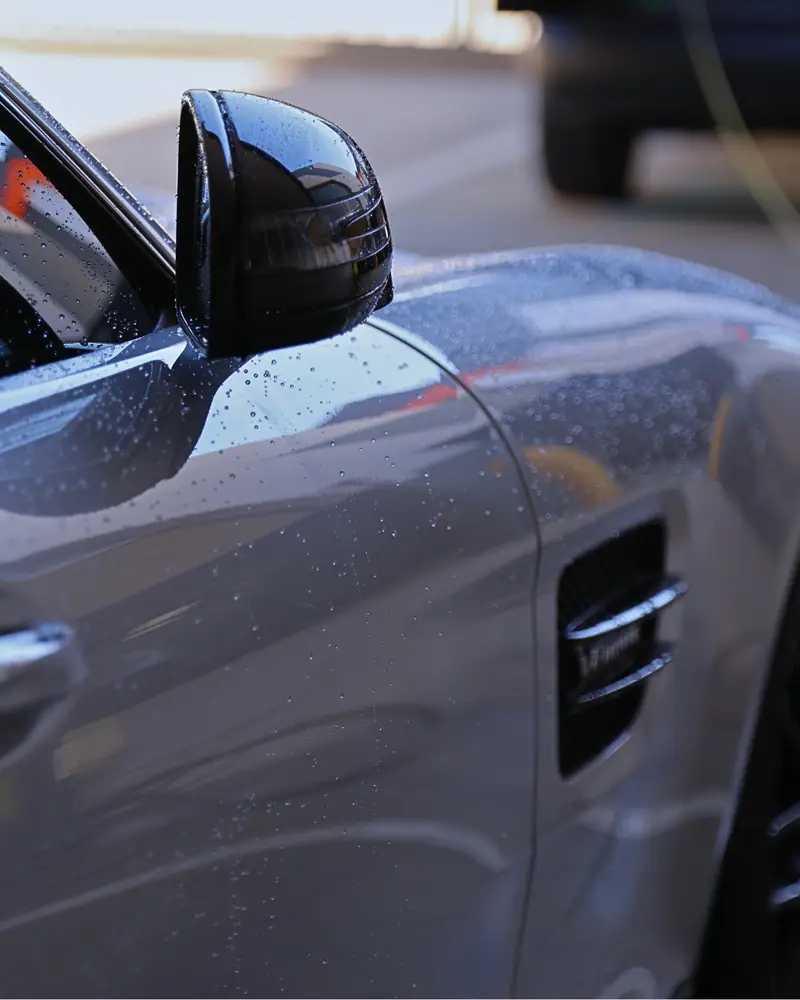 Water beads on a grey luxury car door after a True Graphene coating