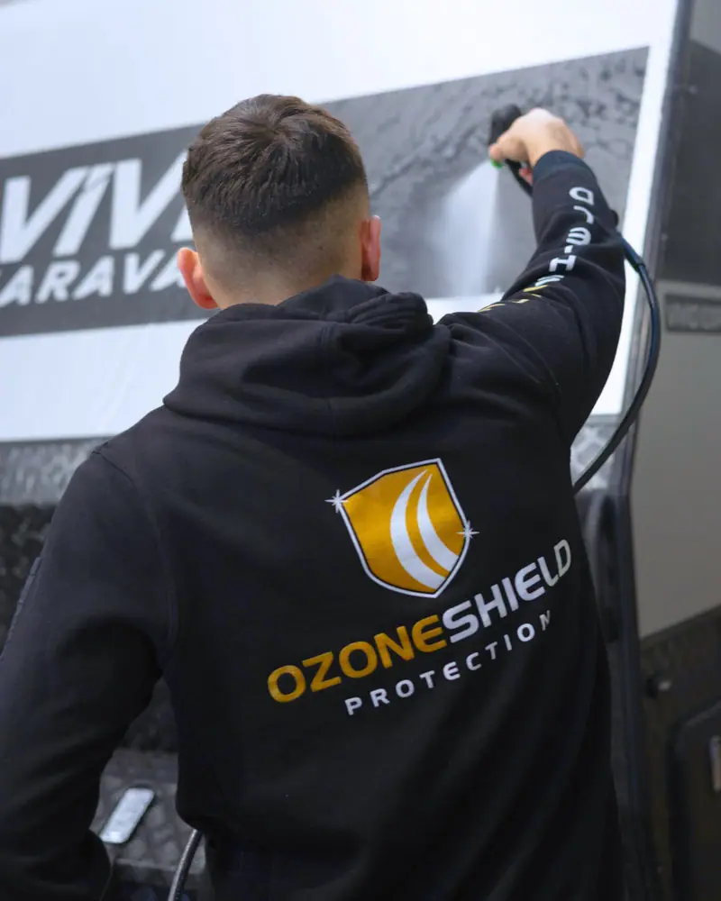 OzoneShield technician spraying anti-microbial protection on a caravan